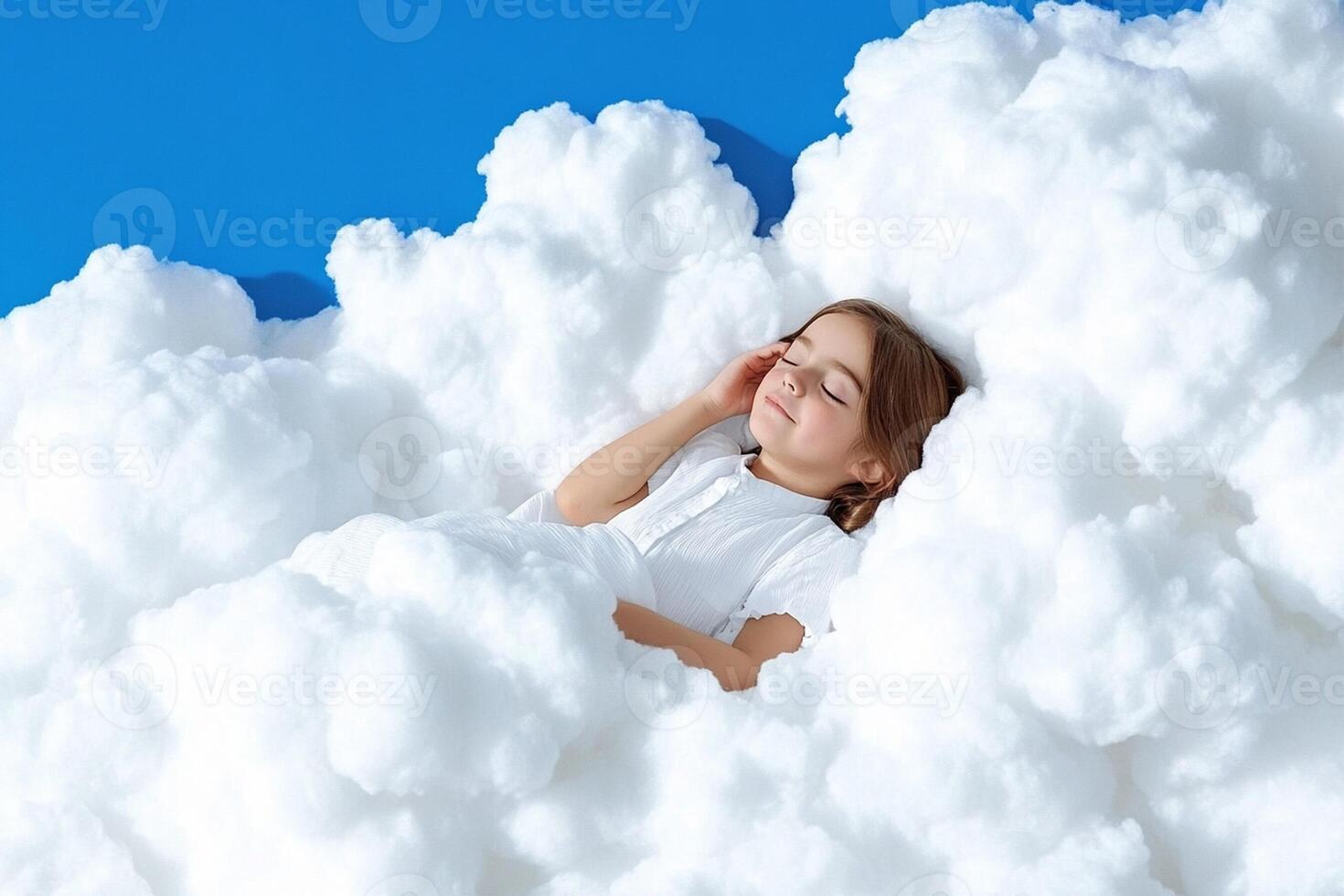 A little girl laying in a cloud of white fluffy clouds photo