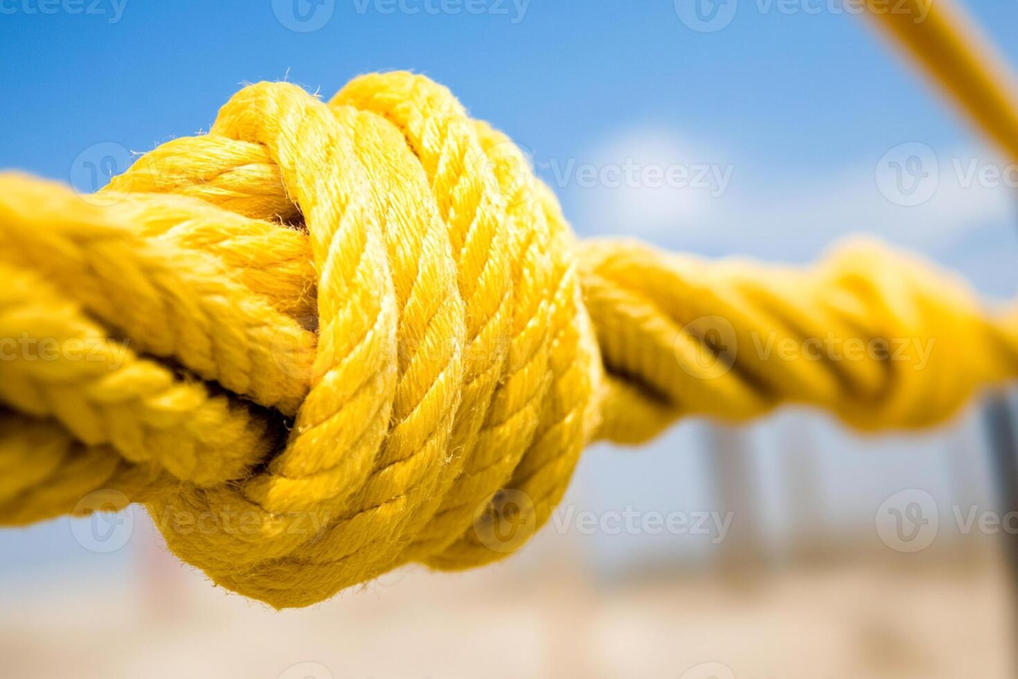 Close up of a yellow rope tied to a fence photo
