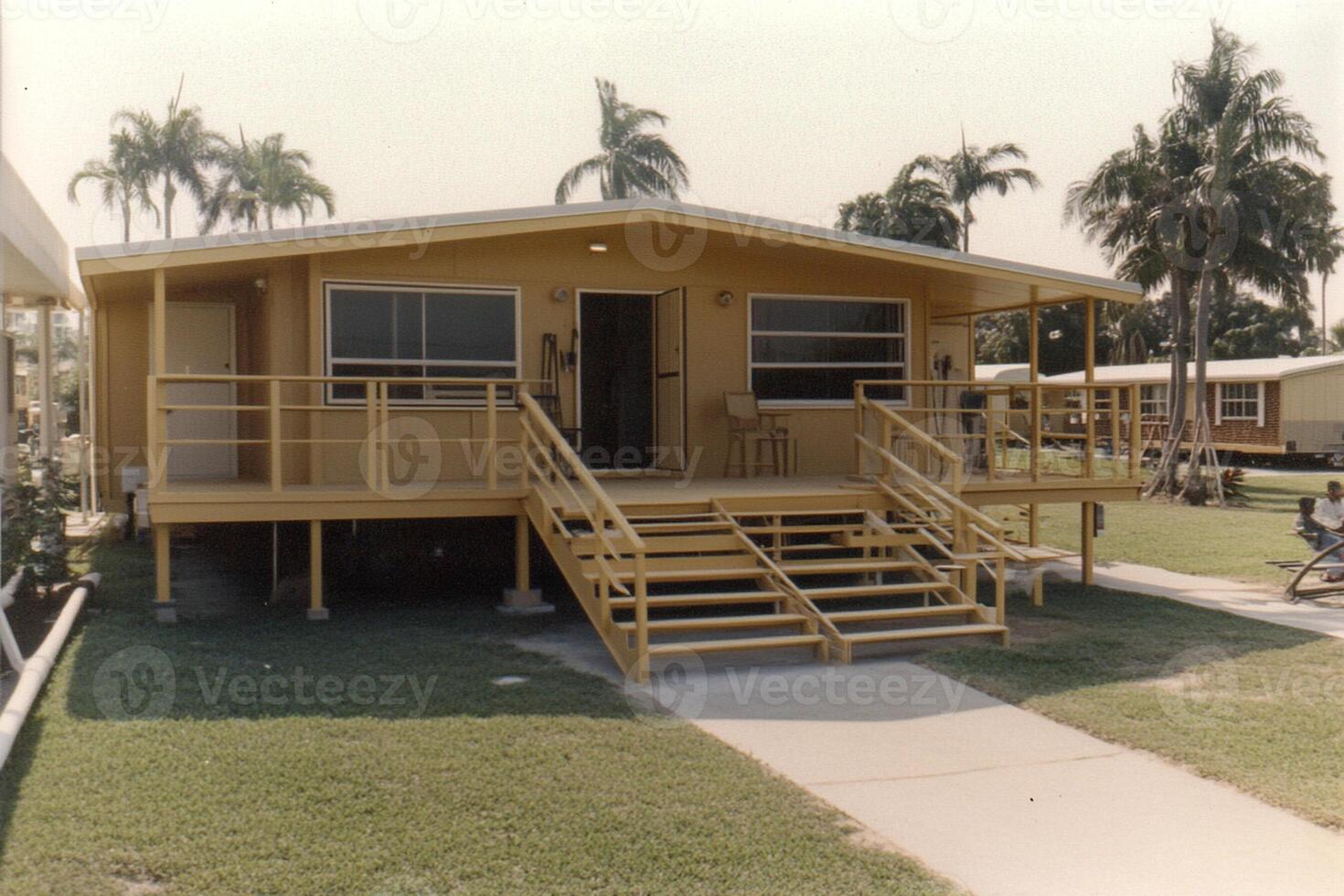 A yellow house with a porch and stairs photo