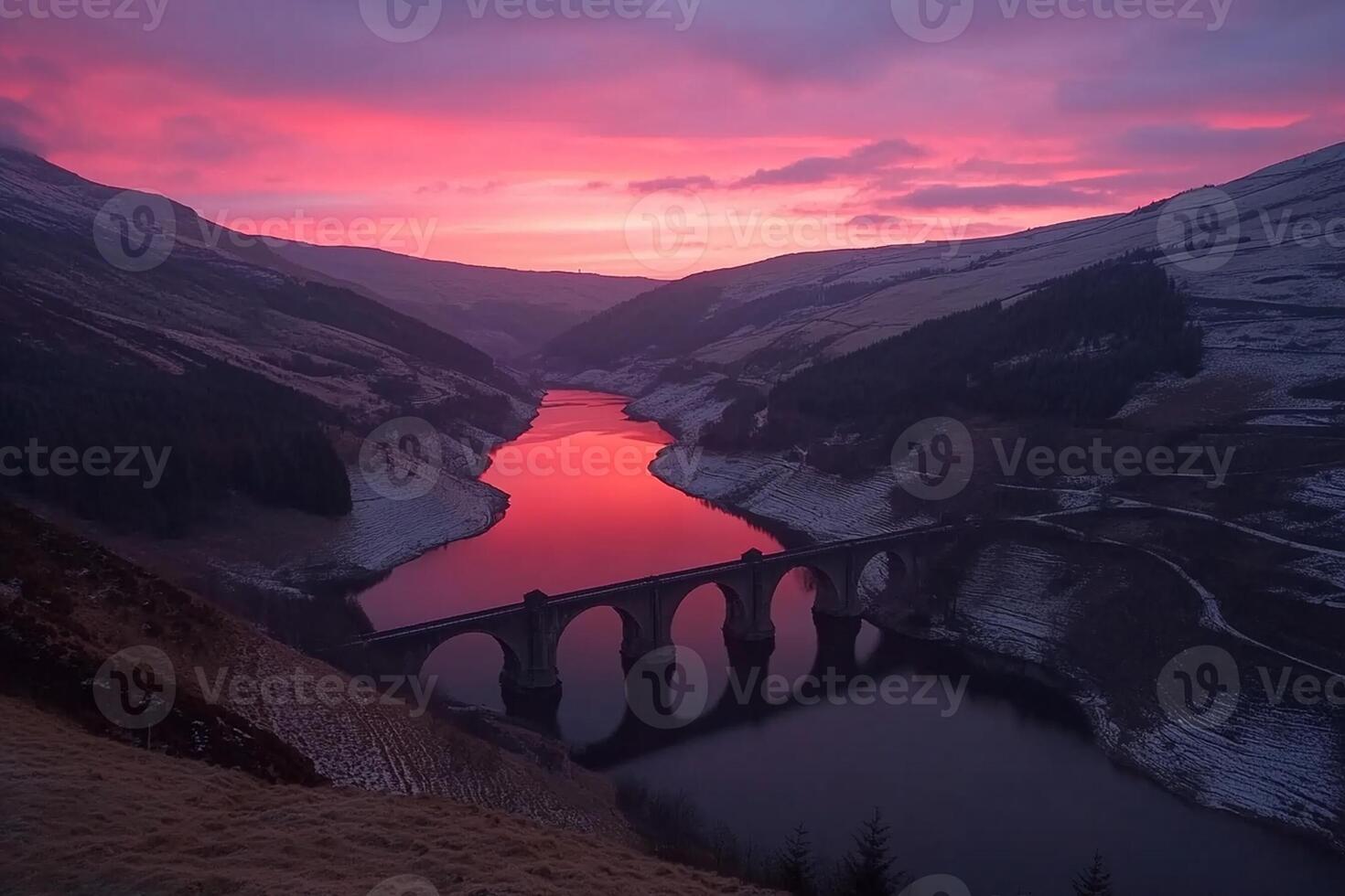 A bridge over a river with a red sky photo