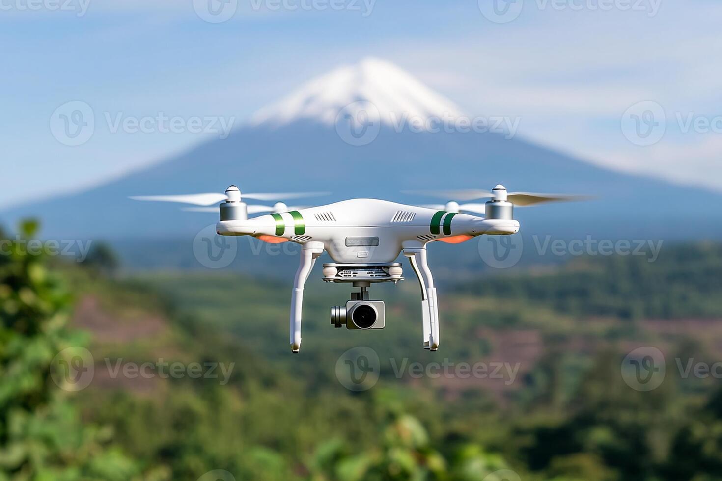 A white drone flying over a mountain with a green tree photo