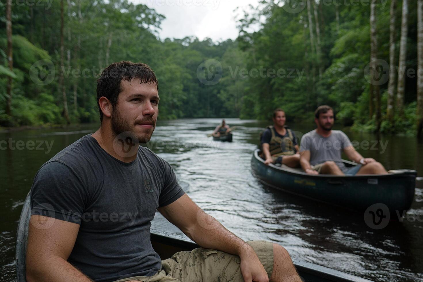 A man in a canoe with two other men in the water photo