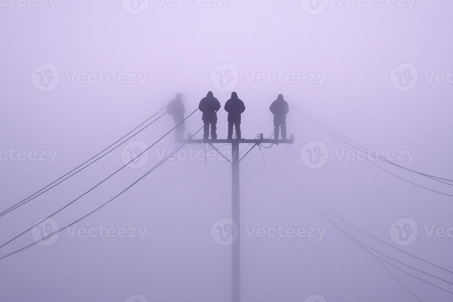 Three people stand on top of a telephone pole in the fog photo