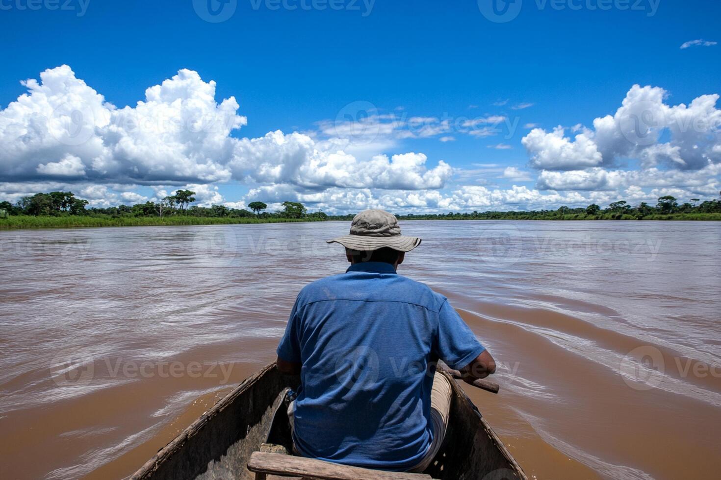 A man in a boat on a river with clouds in the background photo