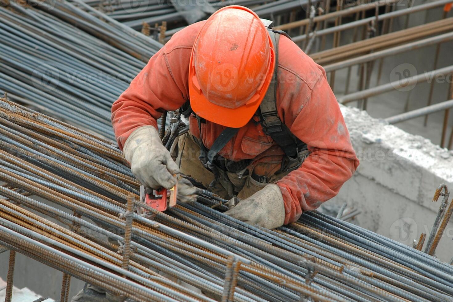 A construction worker using a metal rod to build a structure photo
