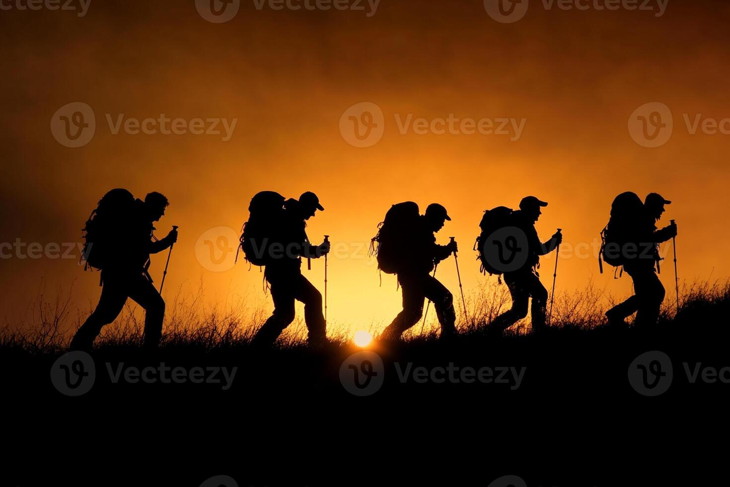 Silhouette of a group of hikers at sunset photo