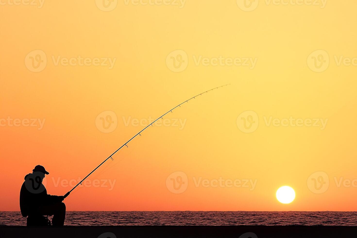 A man sitting on the beach with a fishing rod photo
