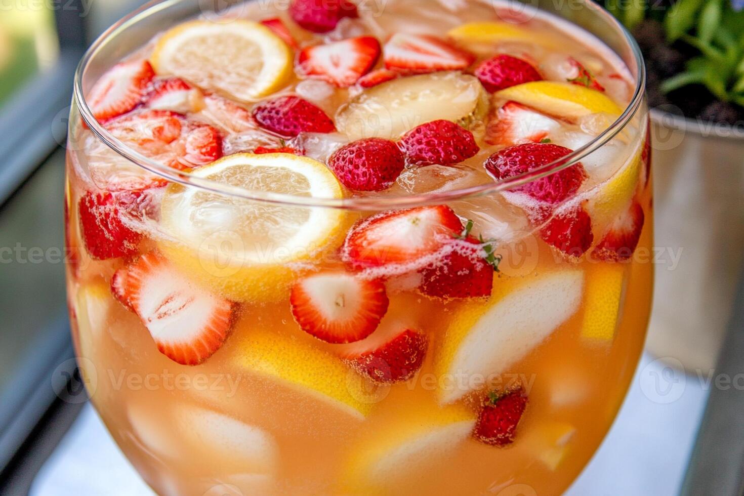 A glass of lemonade with strawberries and lemons photo