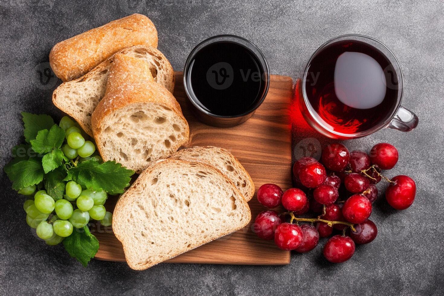 Bread, grapes and a cup of wine on a cutting board photo