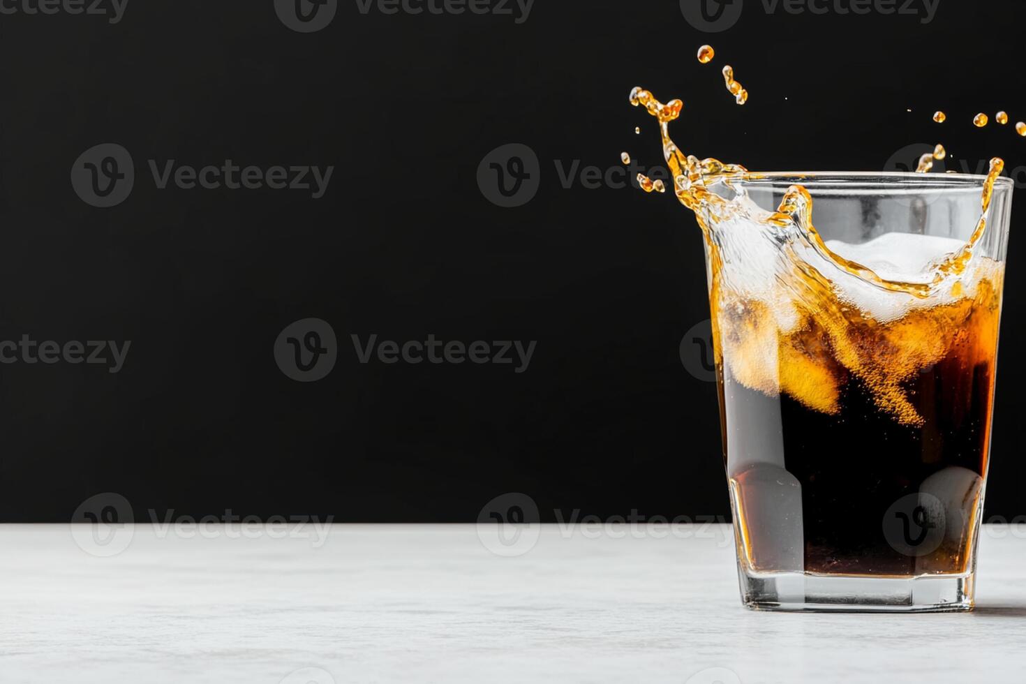 A glass of cola with ice and splash photo