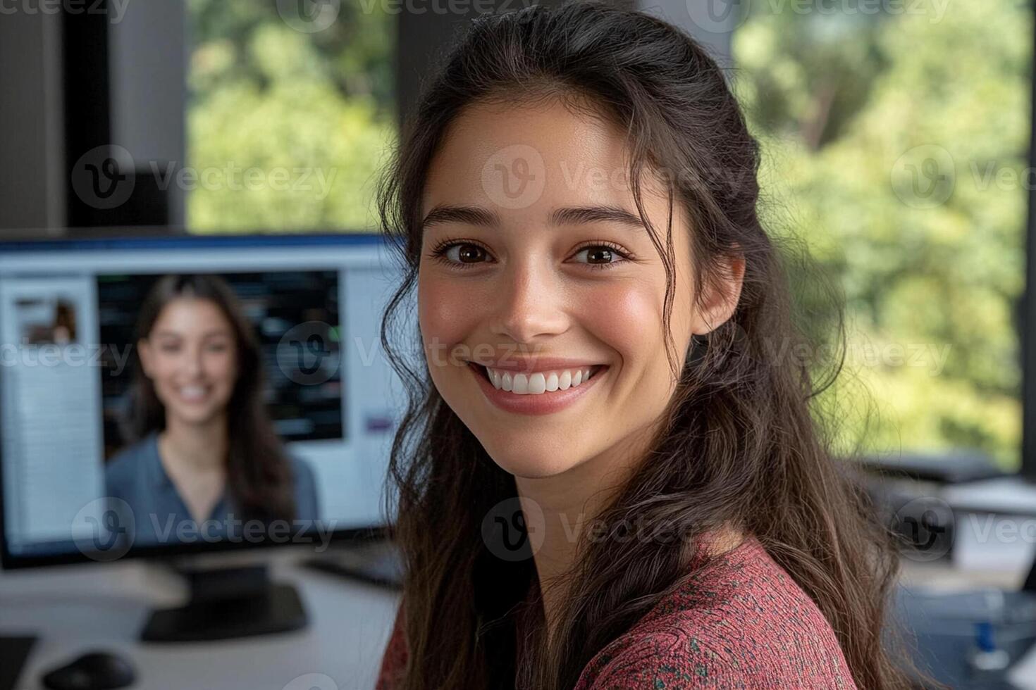 A woman smiling in front of a computer screen photo