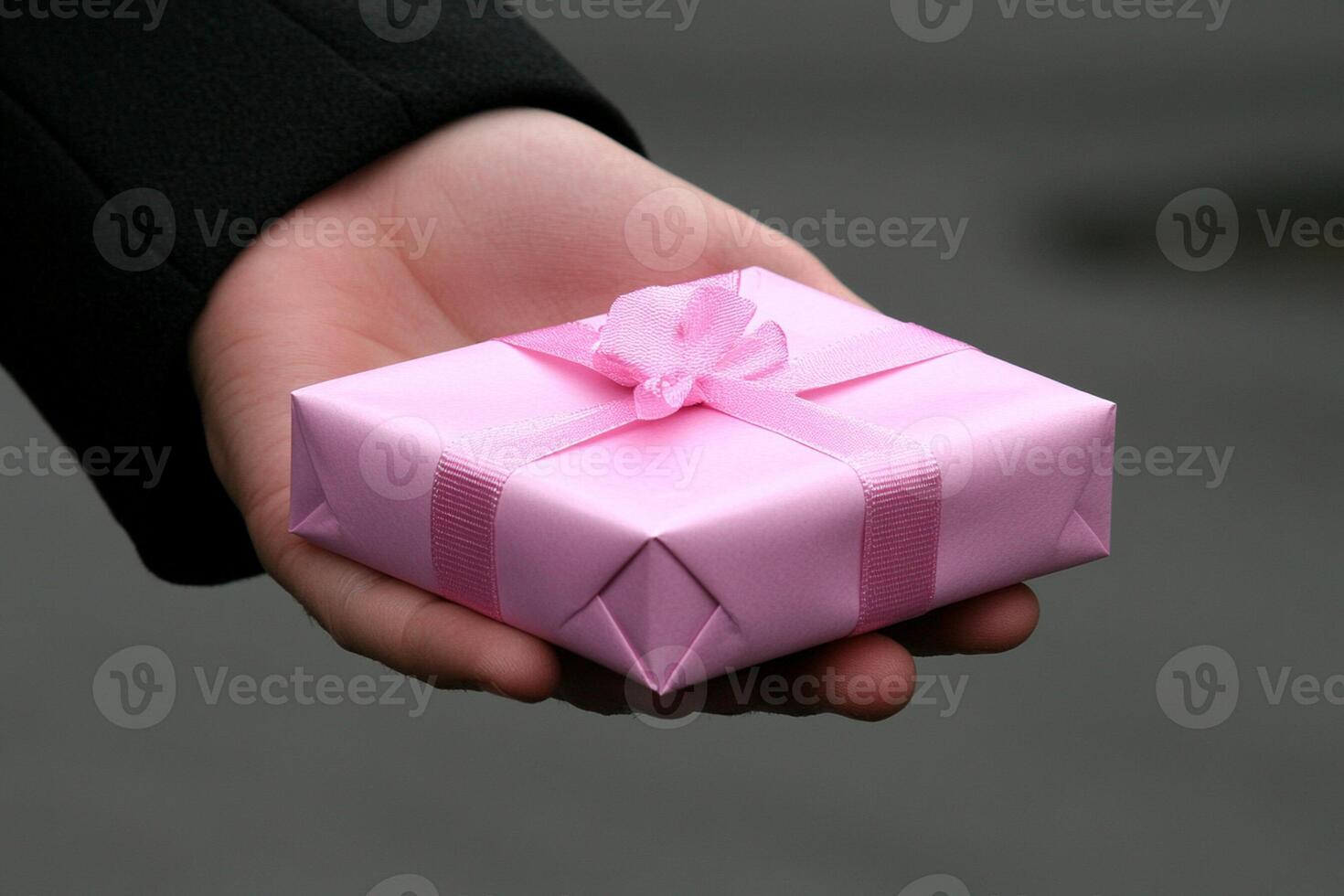 A person holding a pink gift box photo