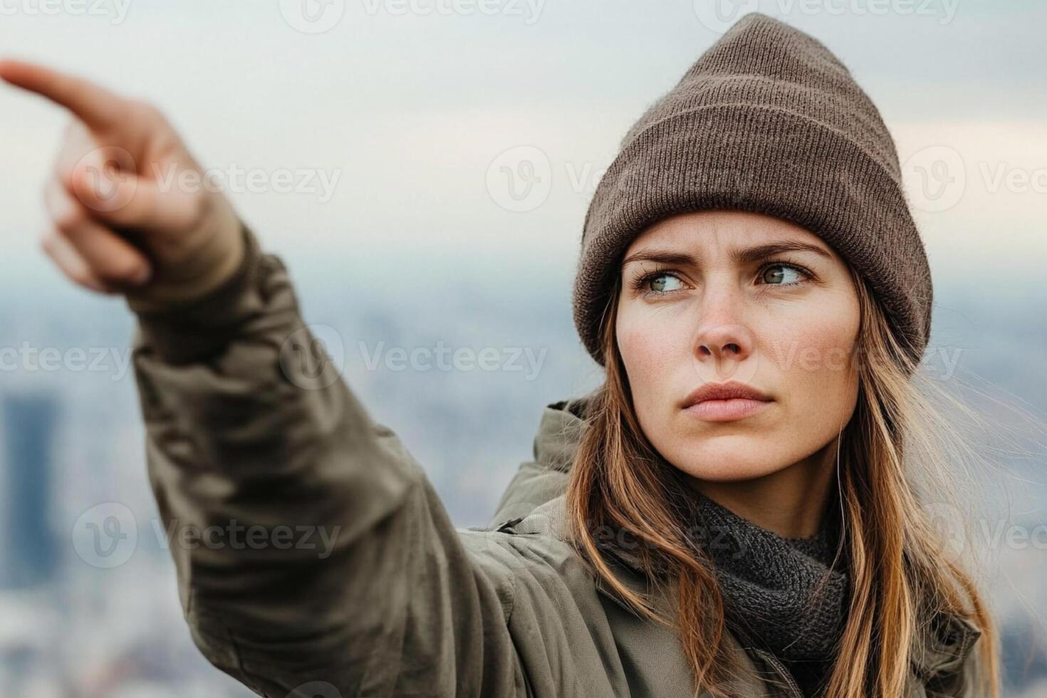 A woman in a beanie pointing at something photo