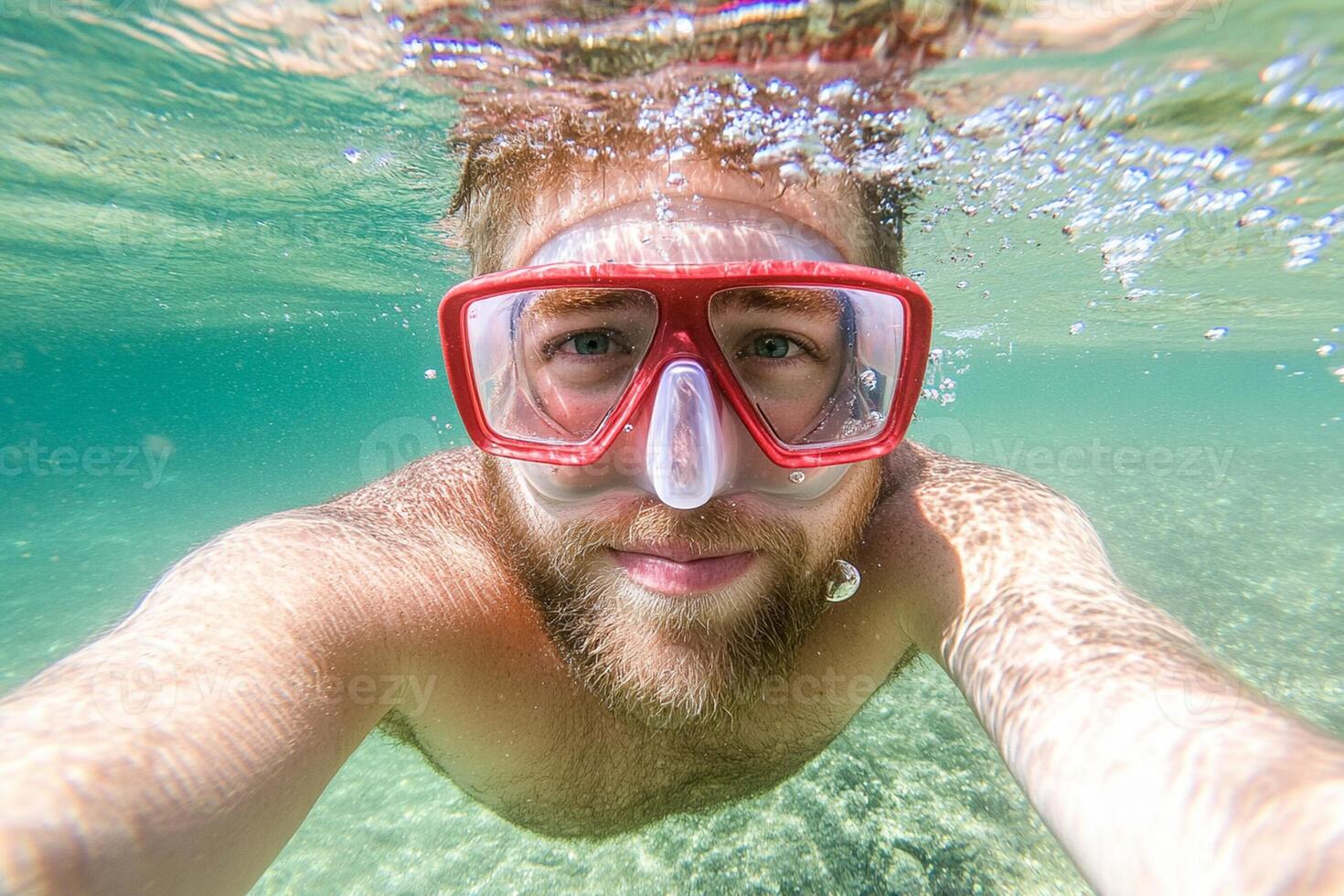 A man wearing a snorkel mask and goggles underwater photo