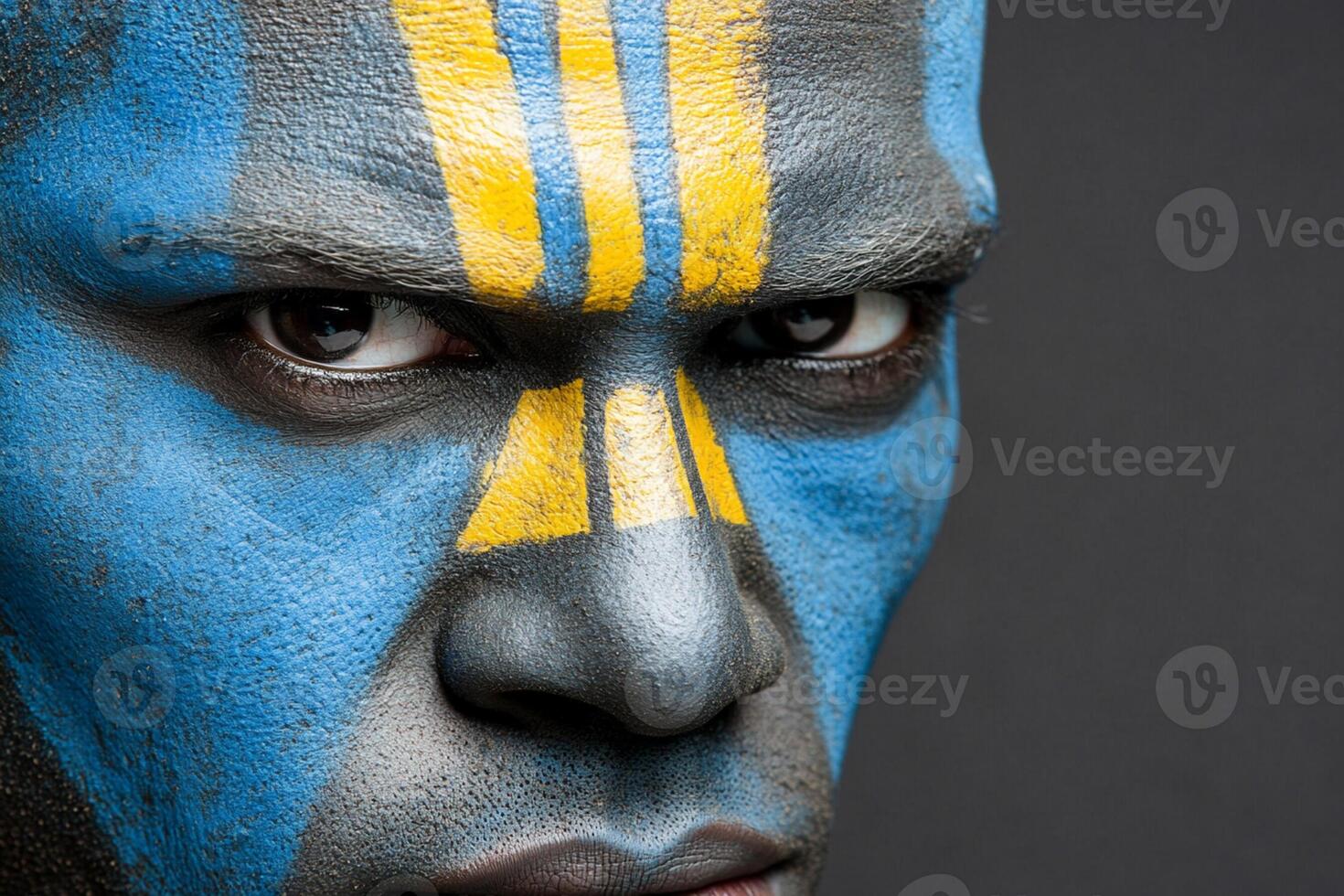 A man with a painted face and blue and yellow stripes photo