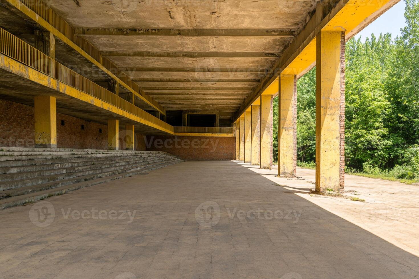 A long empty building with yellow pillars photo
