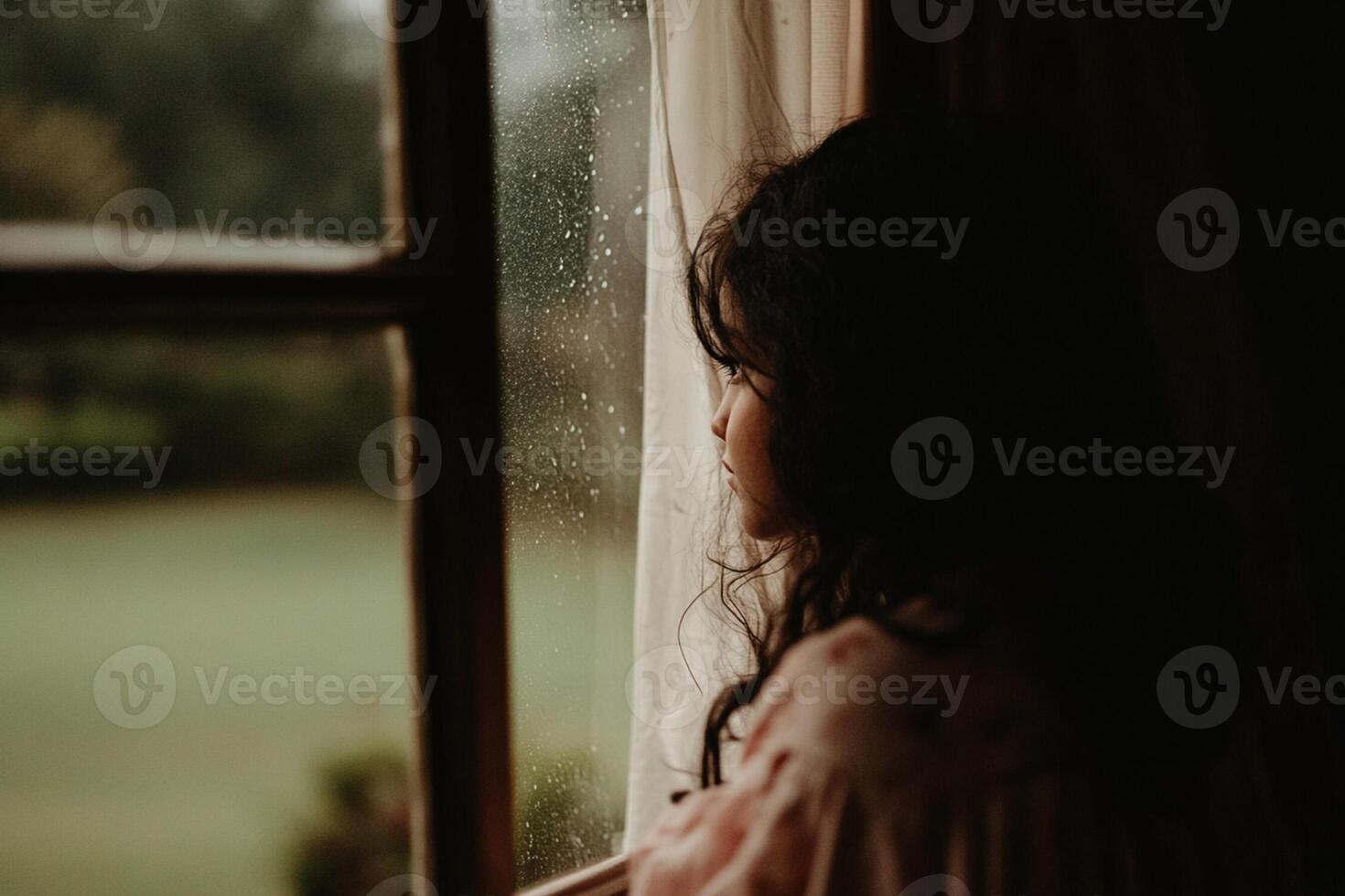 A woman looking out a window in the rain photo