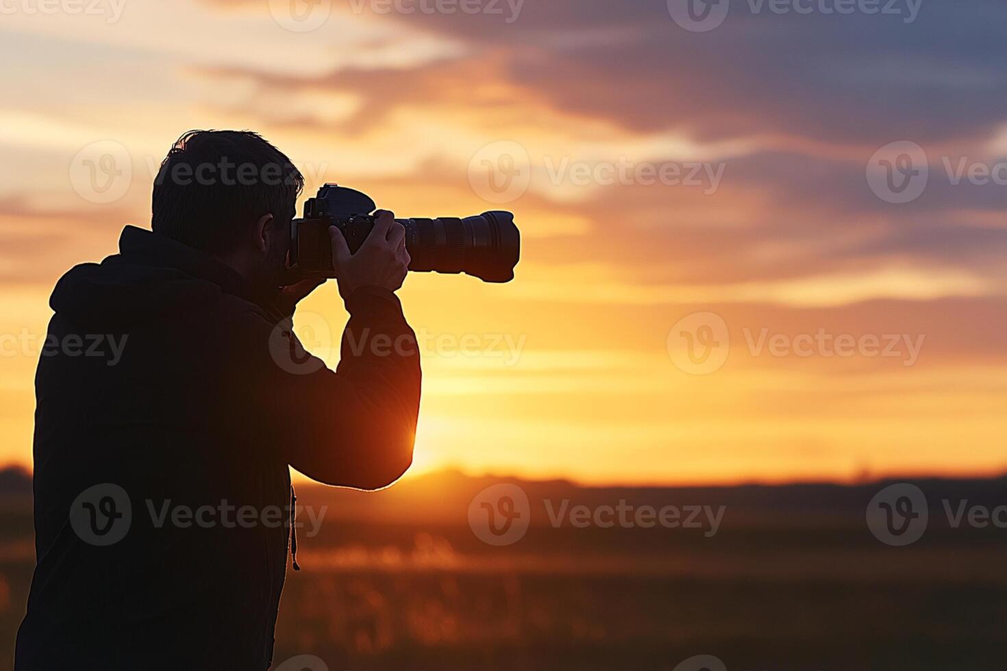 A man taking a photo of the sunset with his camera