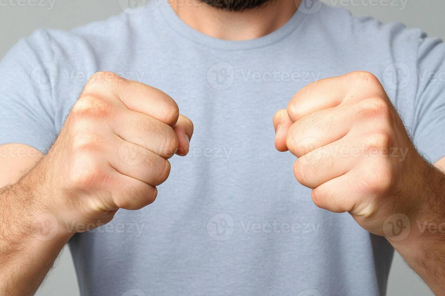 A man with his fists up against a gray background photo