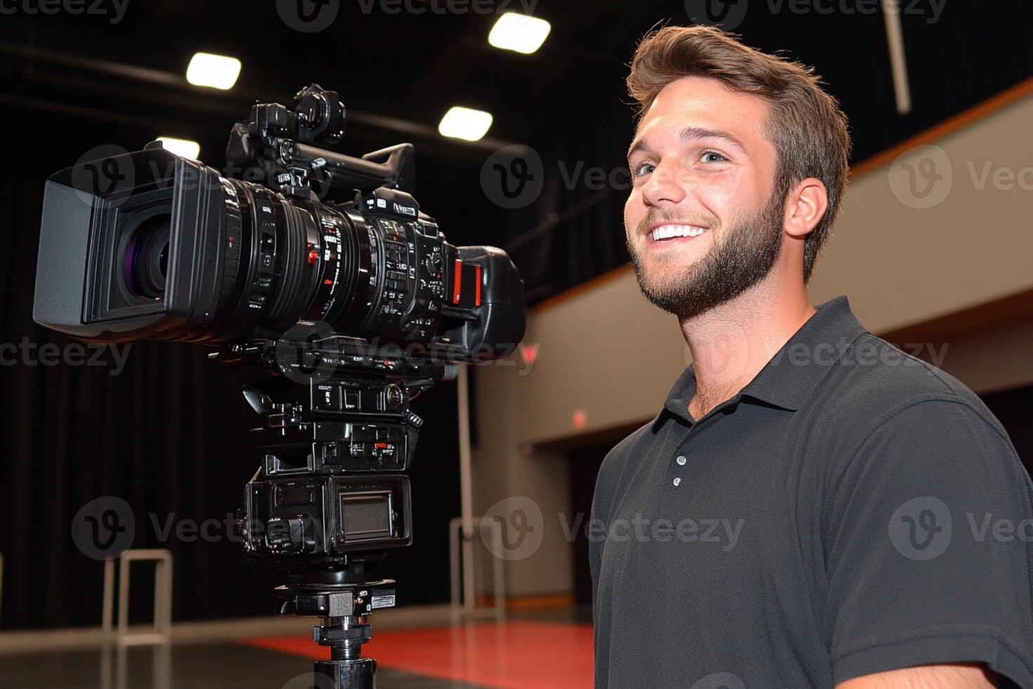 A man smiles while holding a camera in front of him photo