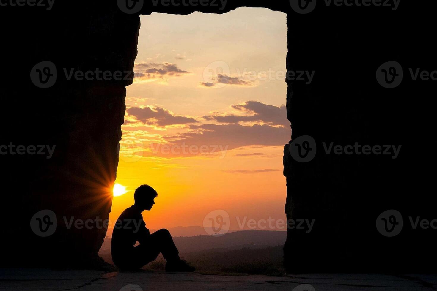A person sitting in front of a doorway at sunset photo