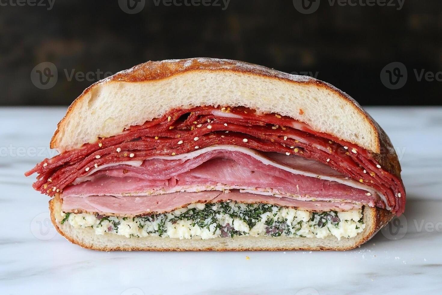A sandwich with meat, cheese and spinach on a white table photo