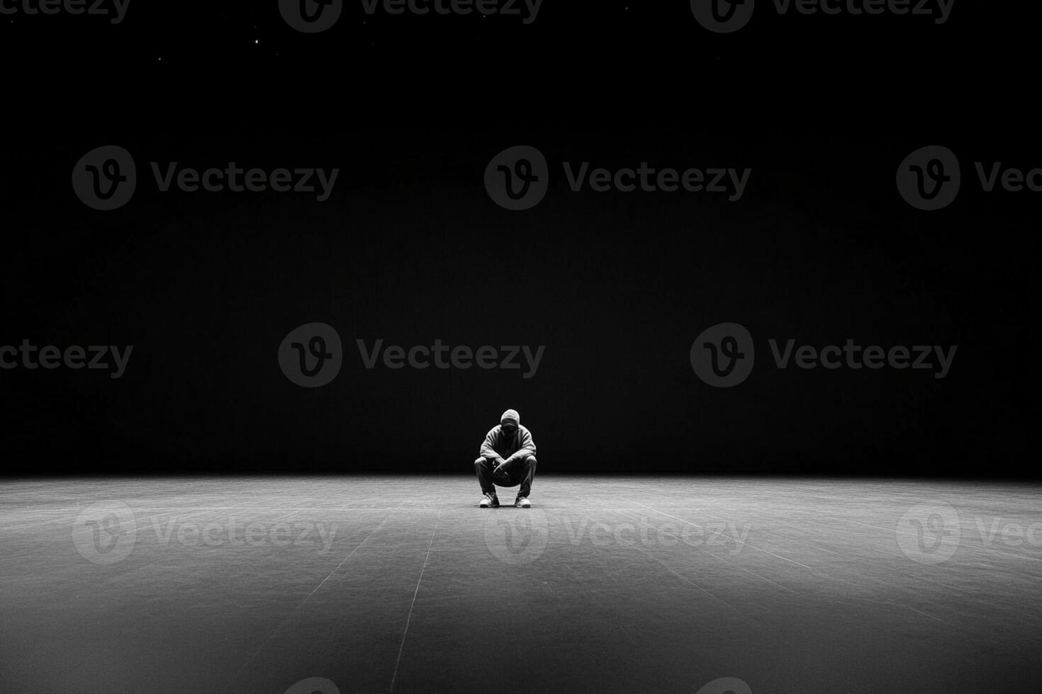 A person sitting on the floor in a dark room photo