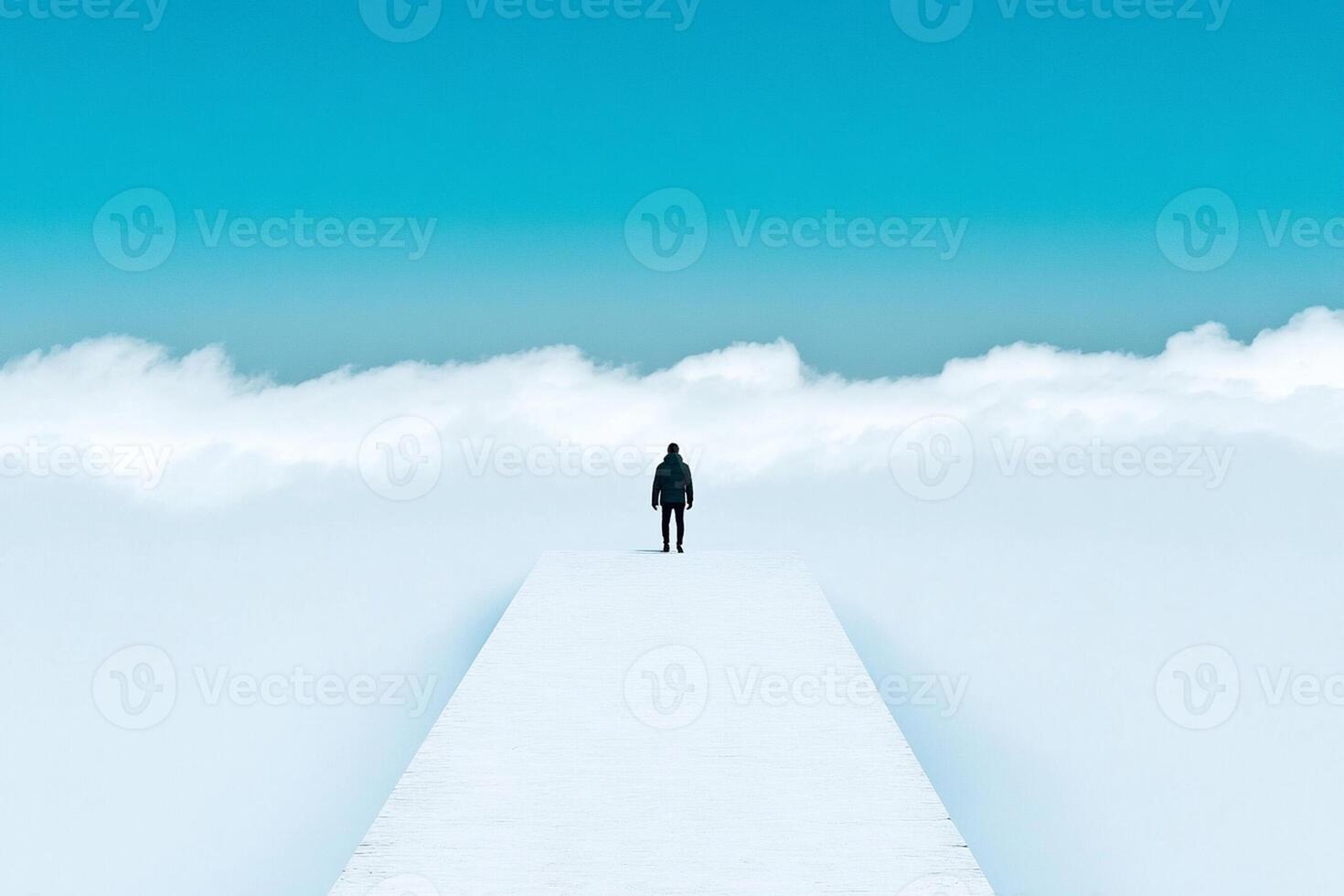 A man standing on a path in the middle of a cloud covered sky photo