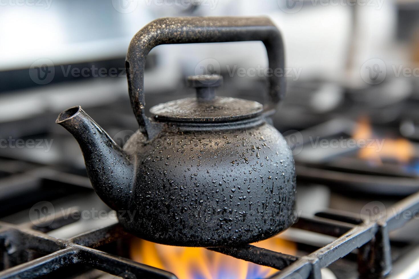 A black teapot sitting on top of a stove photo