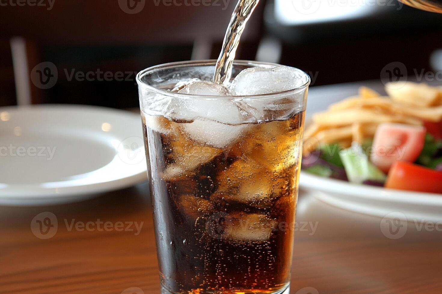 A glass of soda being poured into a glass photo