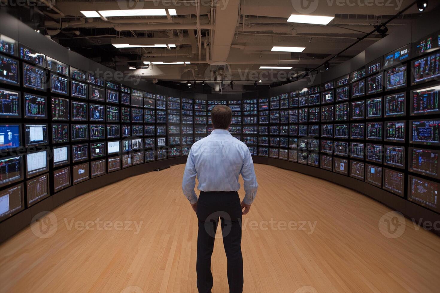 A man standing in front of a large television screen photo