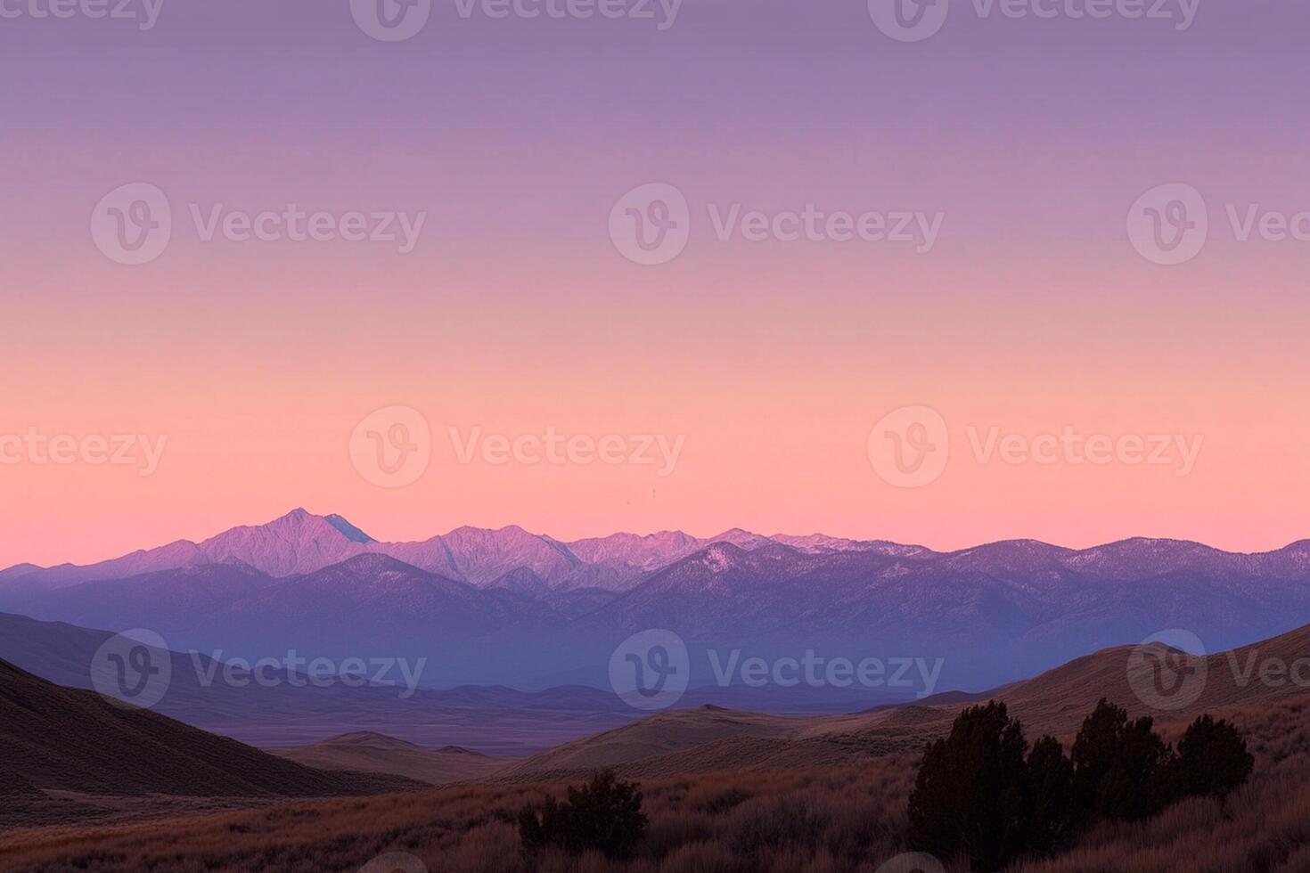 A mountain range with a pink sky and a purple sky photo