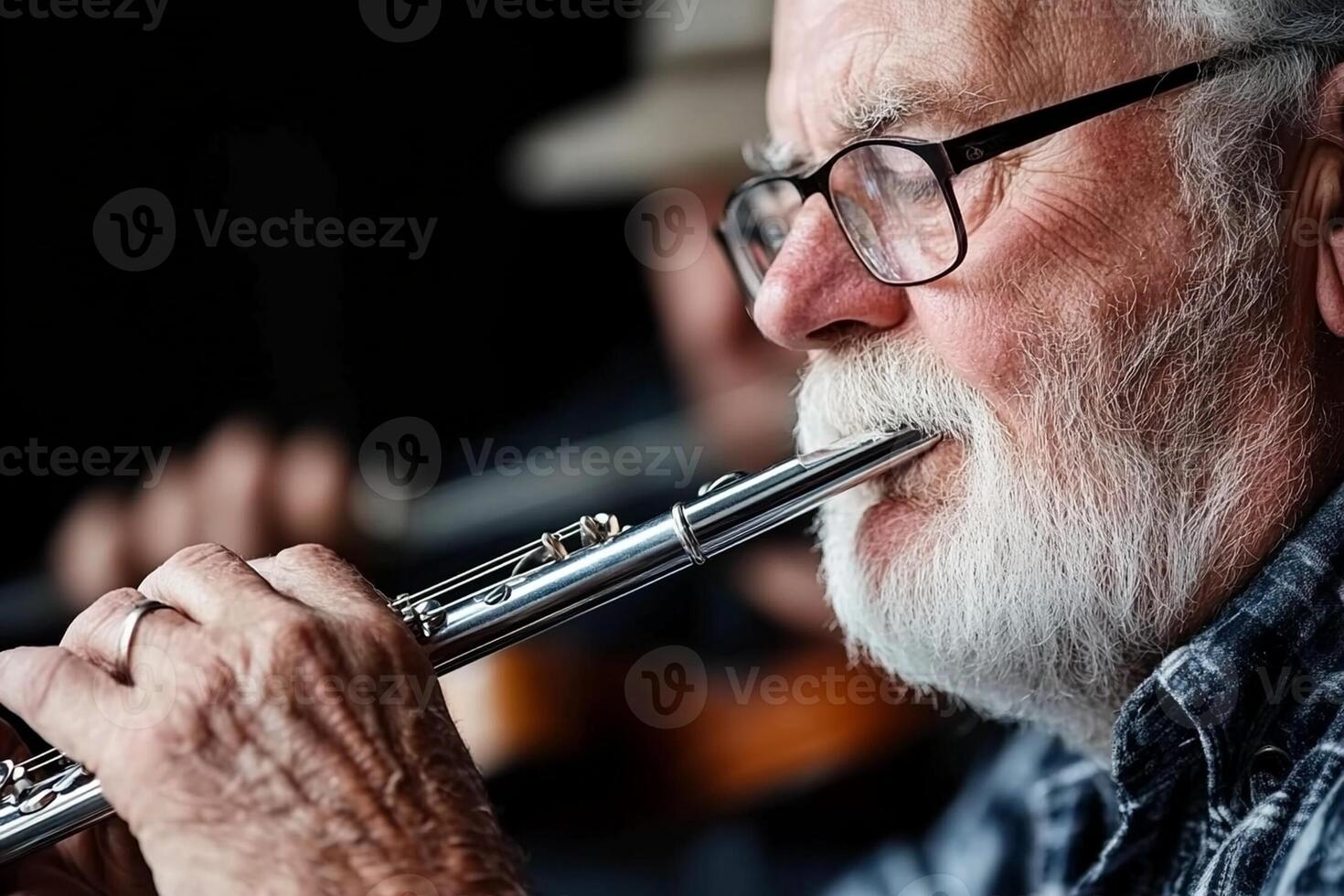 An older man with glasses playing a flute photo