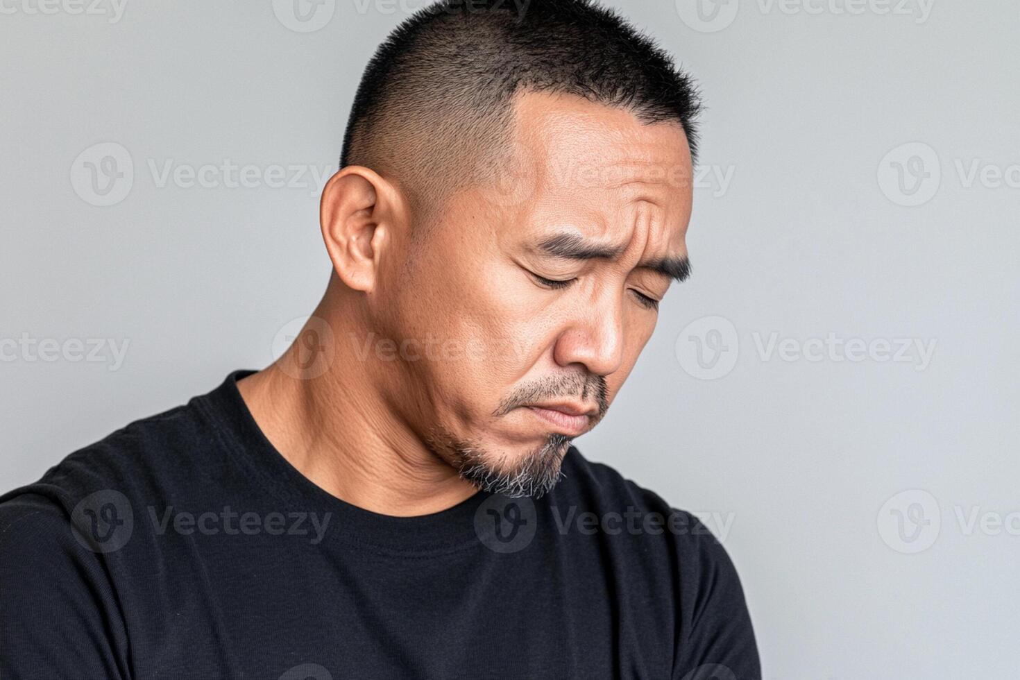 A man with his eyes closed looking down photo