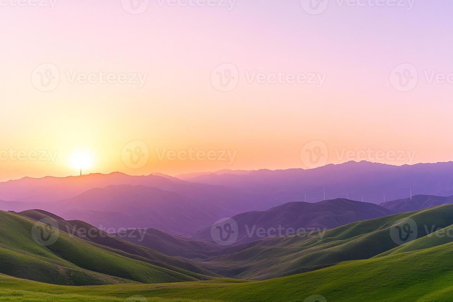 A beautiful sunset over a green hill with mountains in the background photo