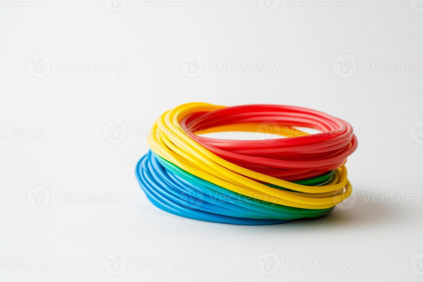 Colorful rubber bands stacked creatively on a white surface showcasing vibrant hues in a playful arrangement during daylight photo