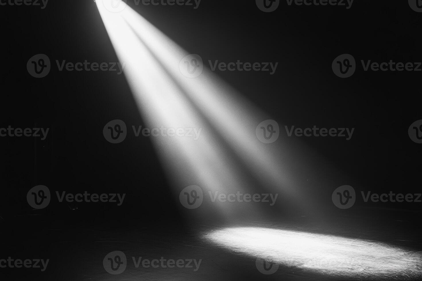Close-up of a solitary light beam cutting through darkness, illuminating a circular area on the ground in a dramatic display photo