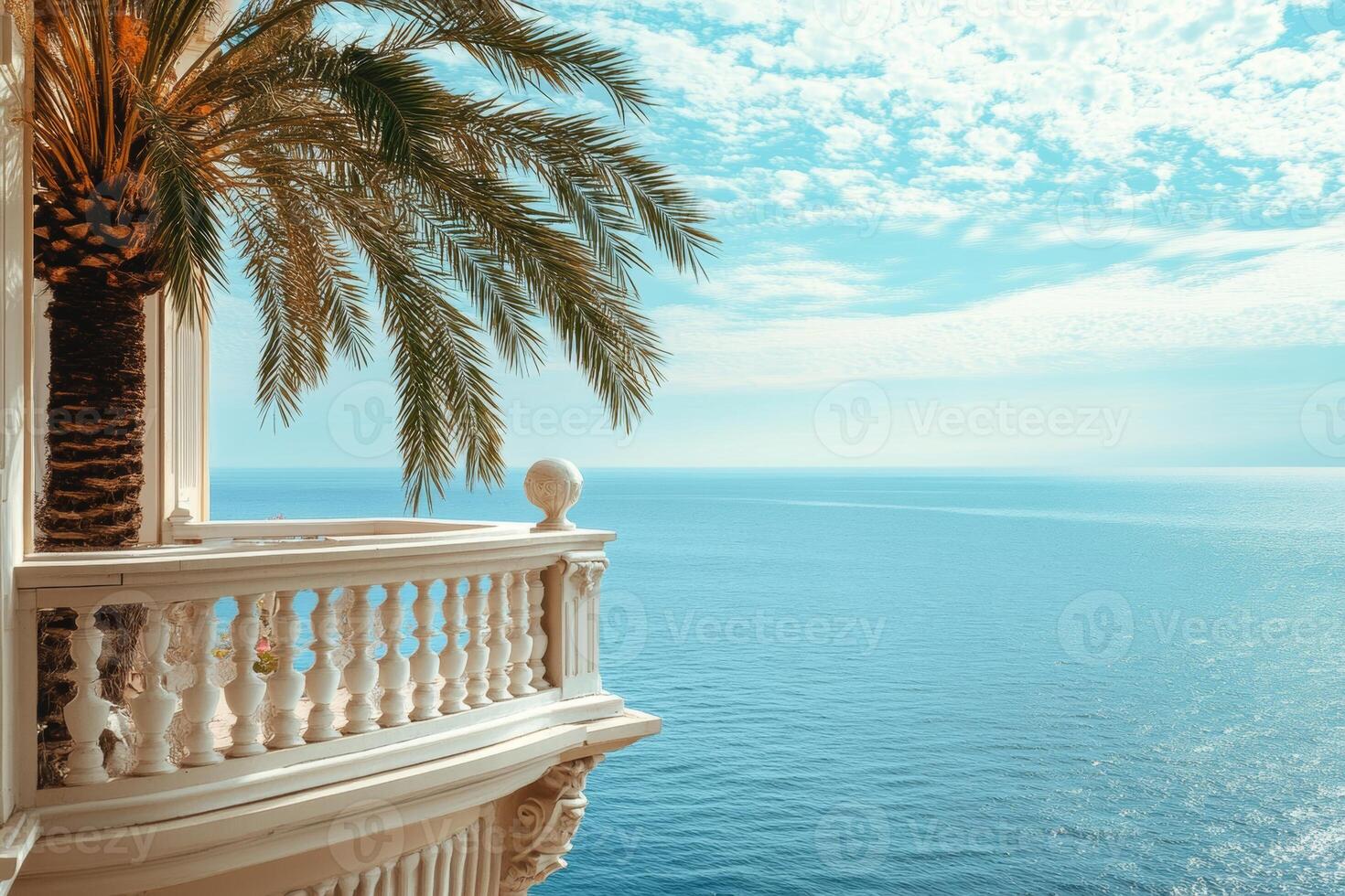 A luxurious hotel balcony overlooking the tranquil sea with a palm tree swaying gently in the warm breeze photo