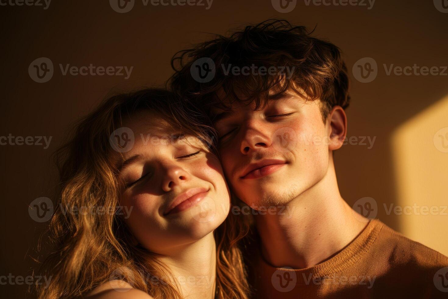 A couple embraces gently, sharing a warm moment together indoors, with soft light creating a cozy atmosphere around them photo