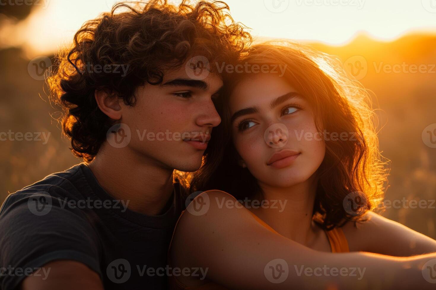 A young couple shares a loving moment outdoors at sunset in warm golden light with minimalistic surroundings photo