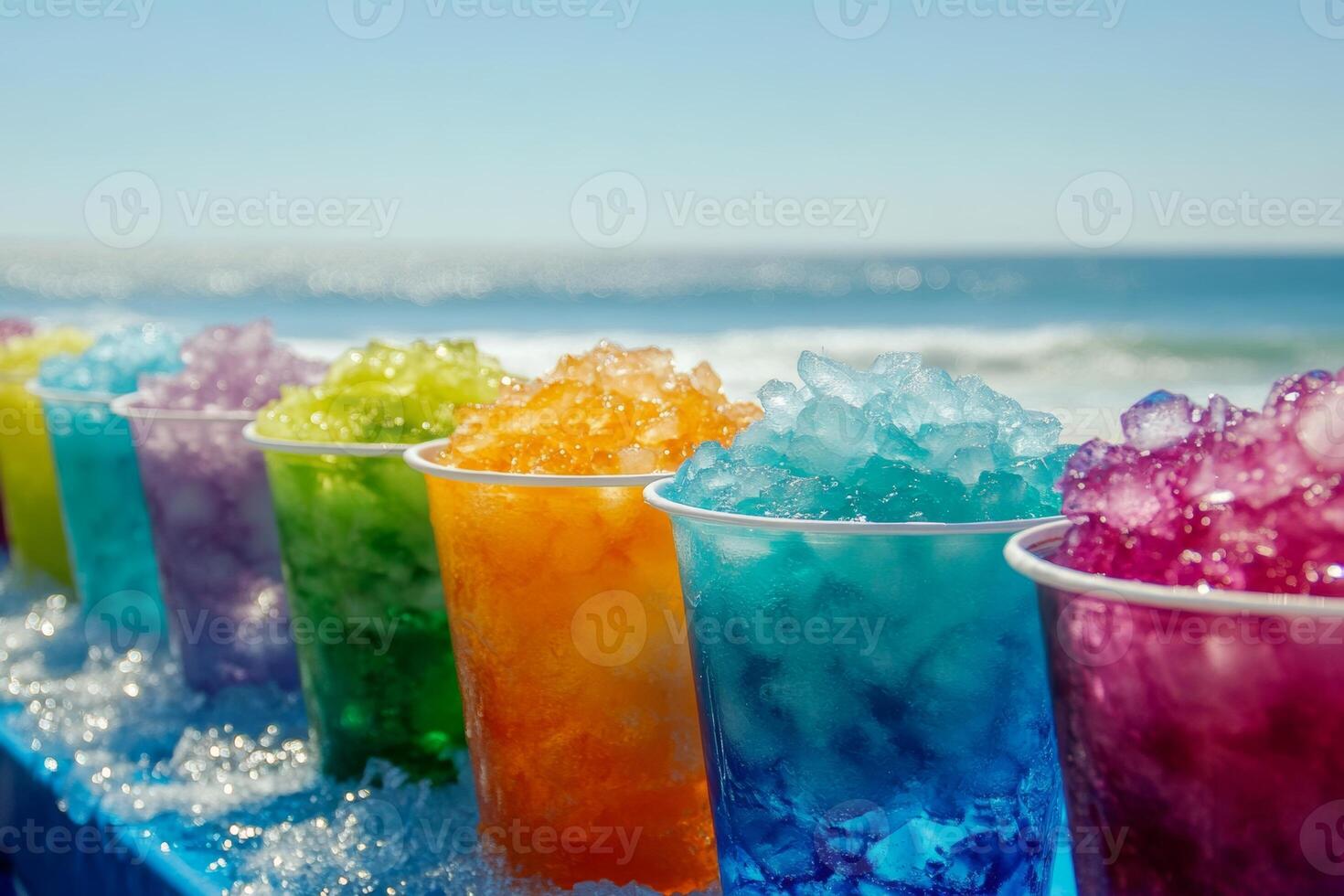Colorful cups of shaved ice lined up on a beach table, with a blue cup among them, brightening the sunny seaside view photo