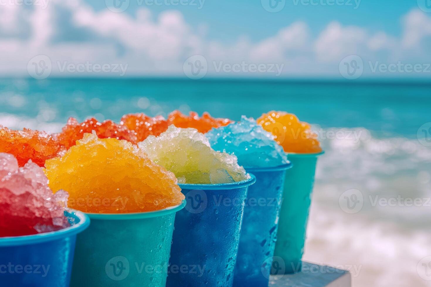 Colorful cups of shaved ice on a beach table with an ocean backdrop during a sunny day photo