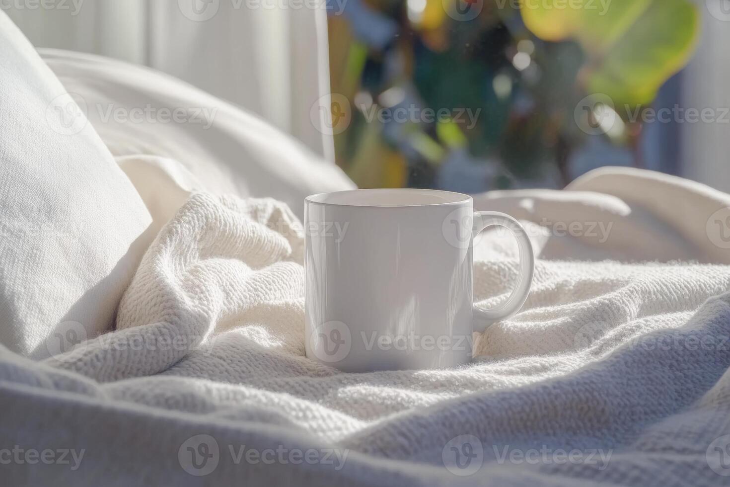 A minimalist white ceramic mug resting on a cozy bed surrounded by soft pillows and blankets in warm evening light photo