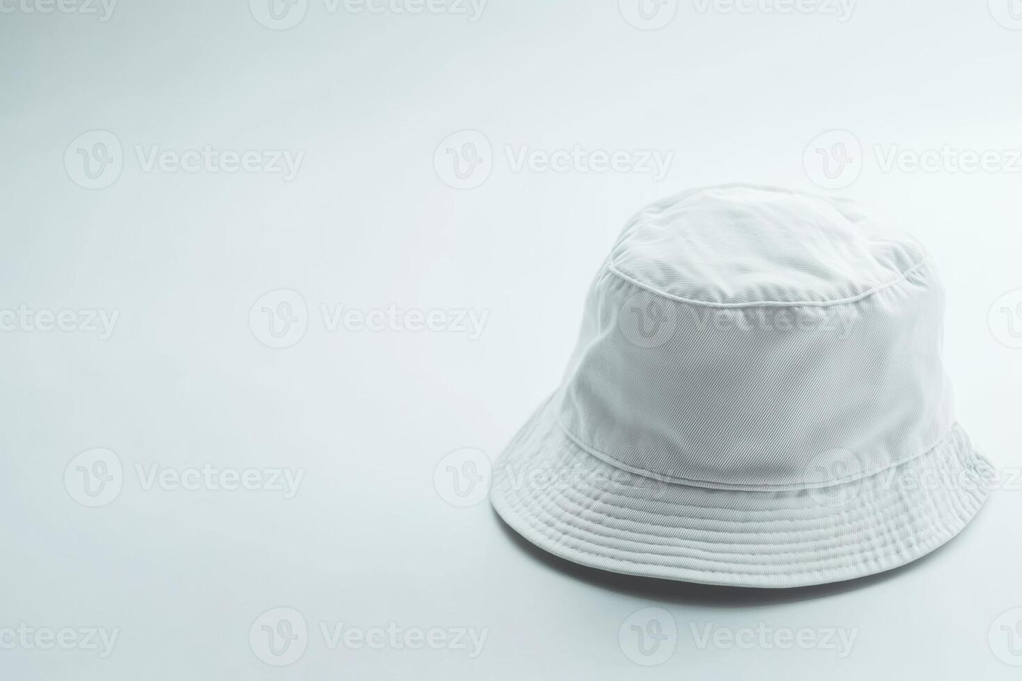 A simple white bucket hat rests on a clean white background, showcasing a minimalist design ideal for summer activities or casual outings photo