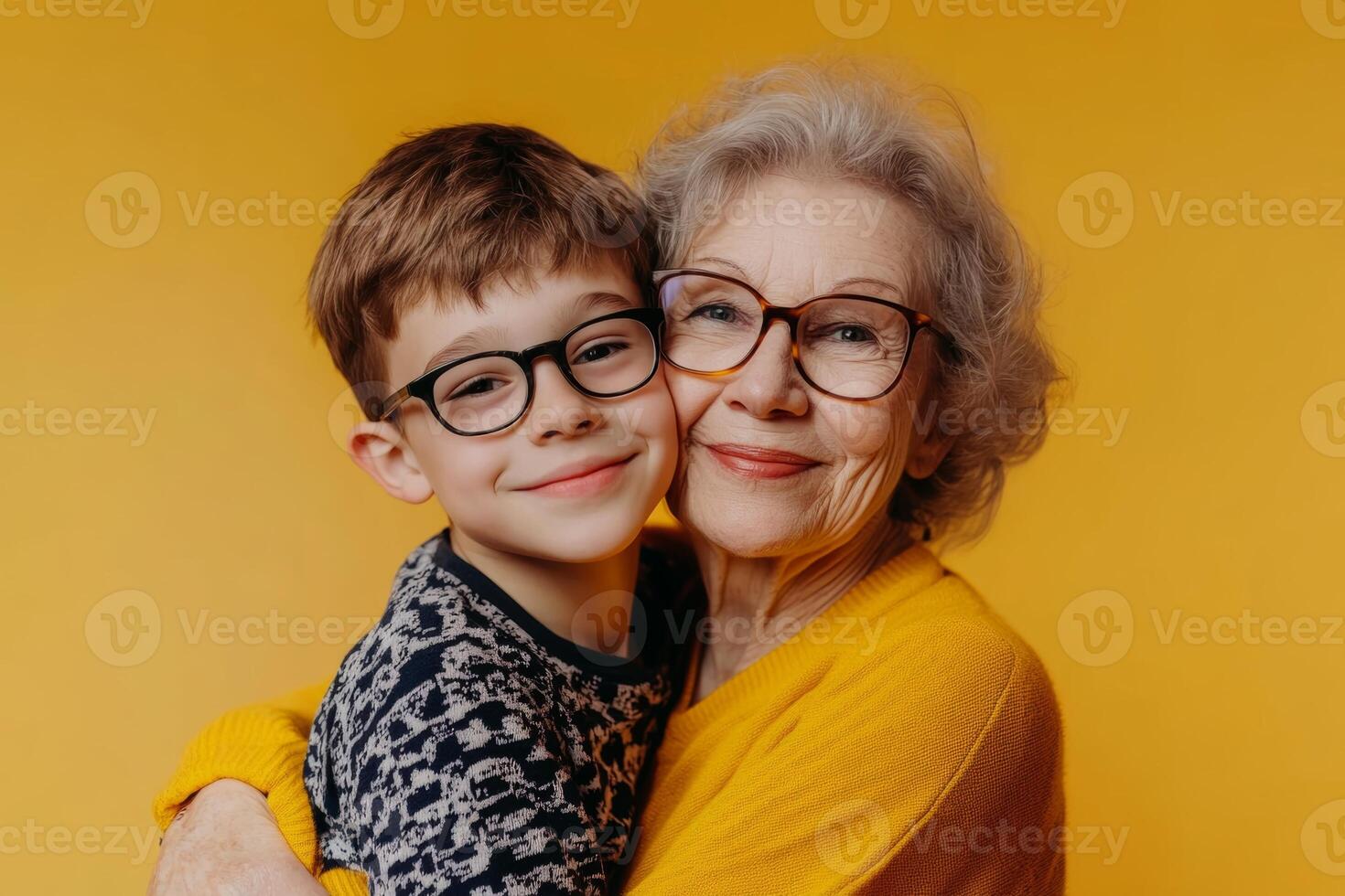 A proud retired mom enjoys a cheerful hug with her glasses-wearing son against a bright yellow background, celebrating their bond photo