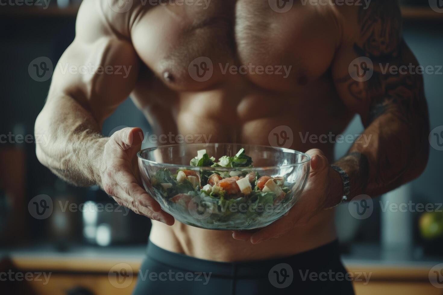 Bodybuilder enjoys a healthy vegan salad in the kitchen from a glass bowl during a nutritious meal prep session photo