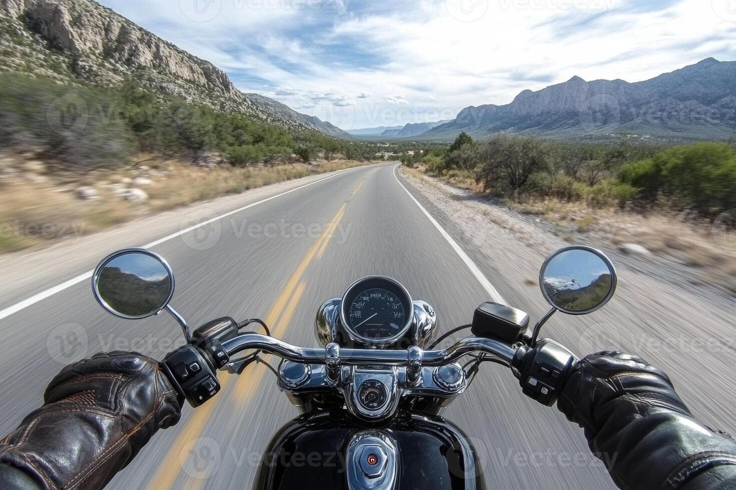 A thrilling motorcycle ride on a winding highway surrounded by stunning mountains in clear weather photo