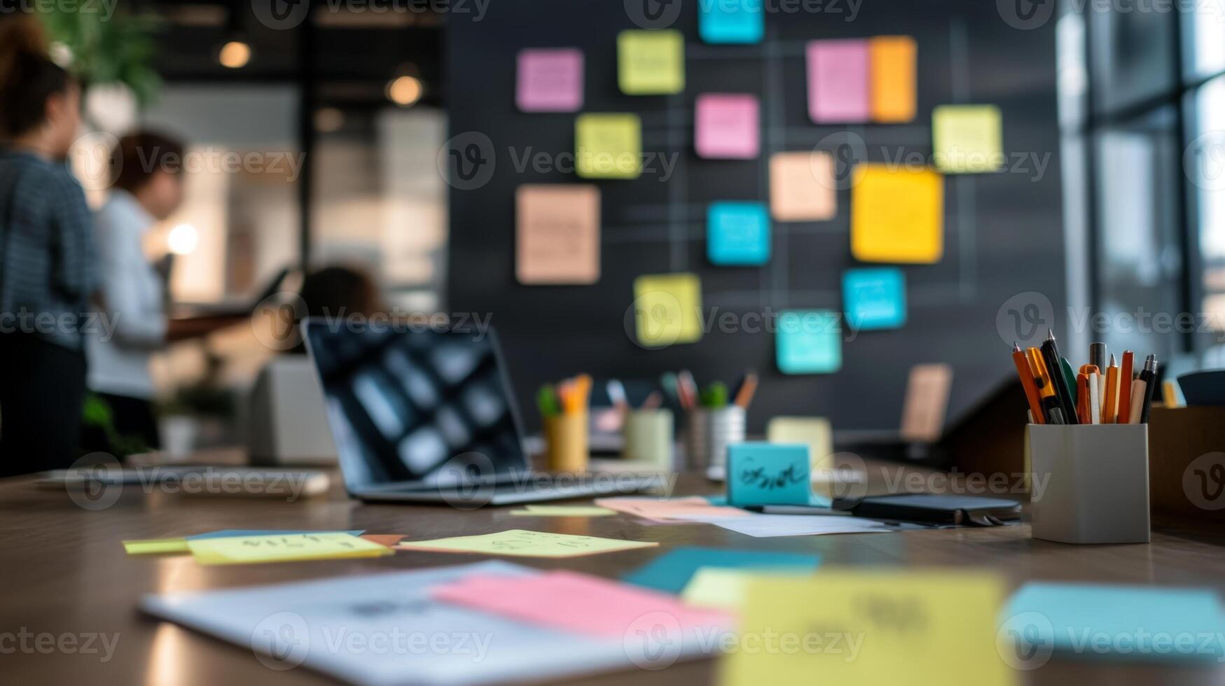 A diverse business team collaborates on ideas in a modern office with laptops and notes scattered on the table during a brainstorming session photo