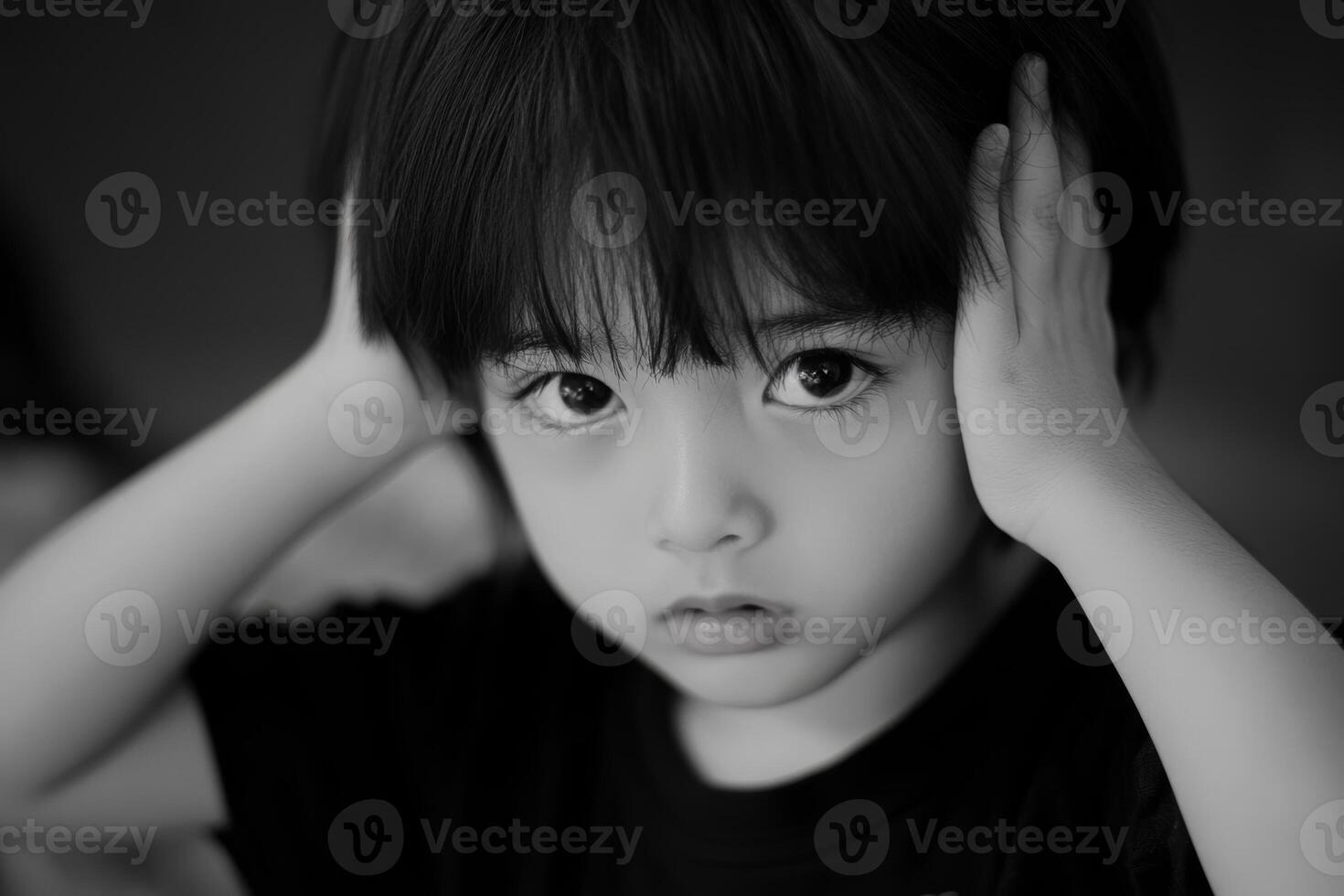 Child shows distress by covering ears in a quiet, indoor setting during a moment of overwhelming emotions photo