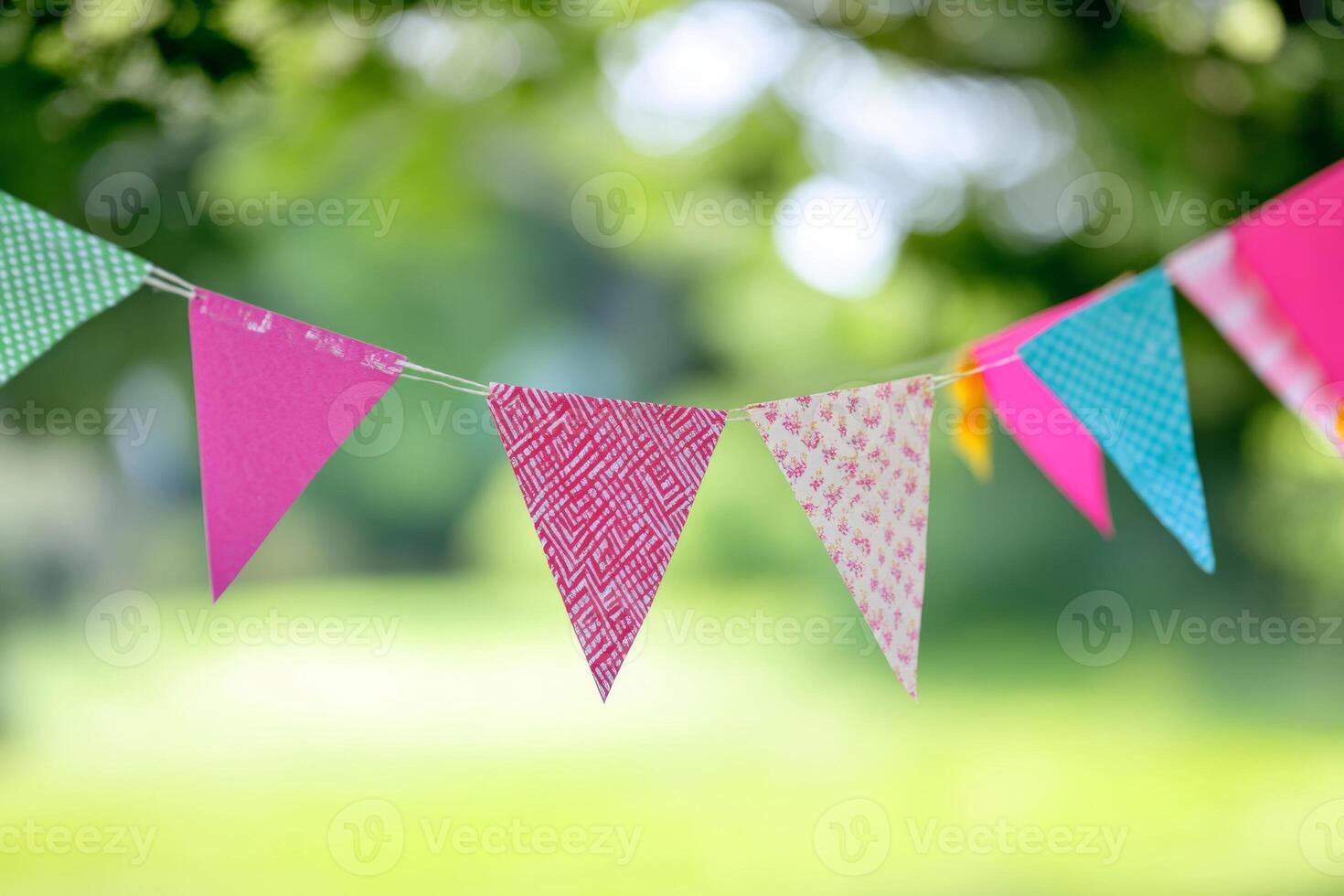 Vibrant bunting flags strung across a lively outdoor celebration in a sunlit park creating a festive atmosphere for attendees photo